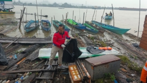 Aksi bersih sungai dengan sampah kayu dan sampah lainnya di tepian sungai