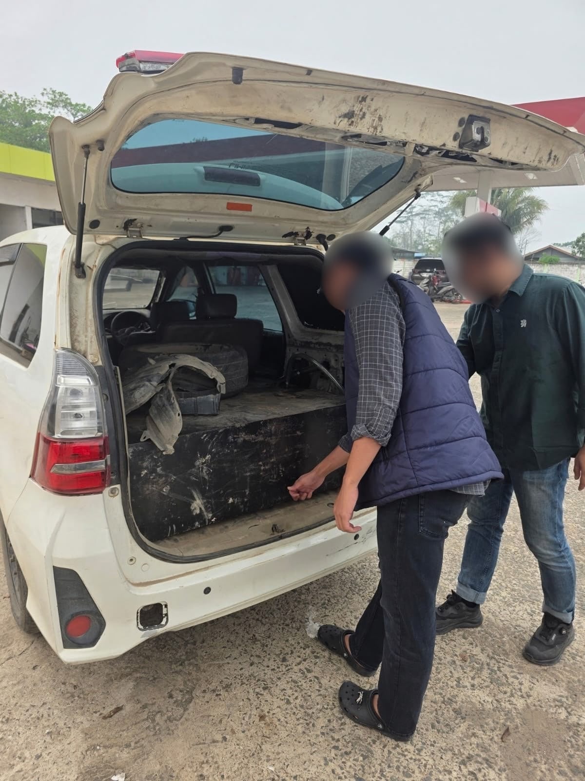 Toyota Avanza putih dengan bagasi terbuka di area SPBU
